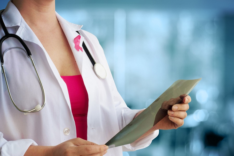 a healthcare professional with the breast cancer symbol