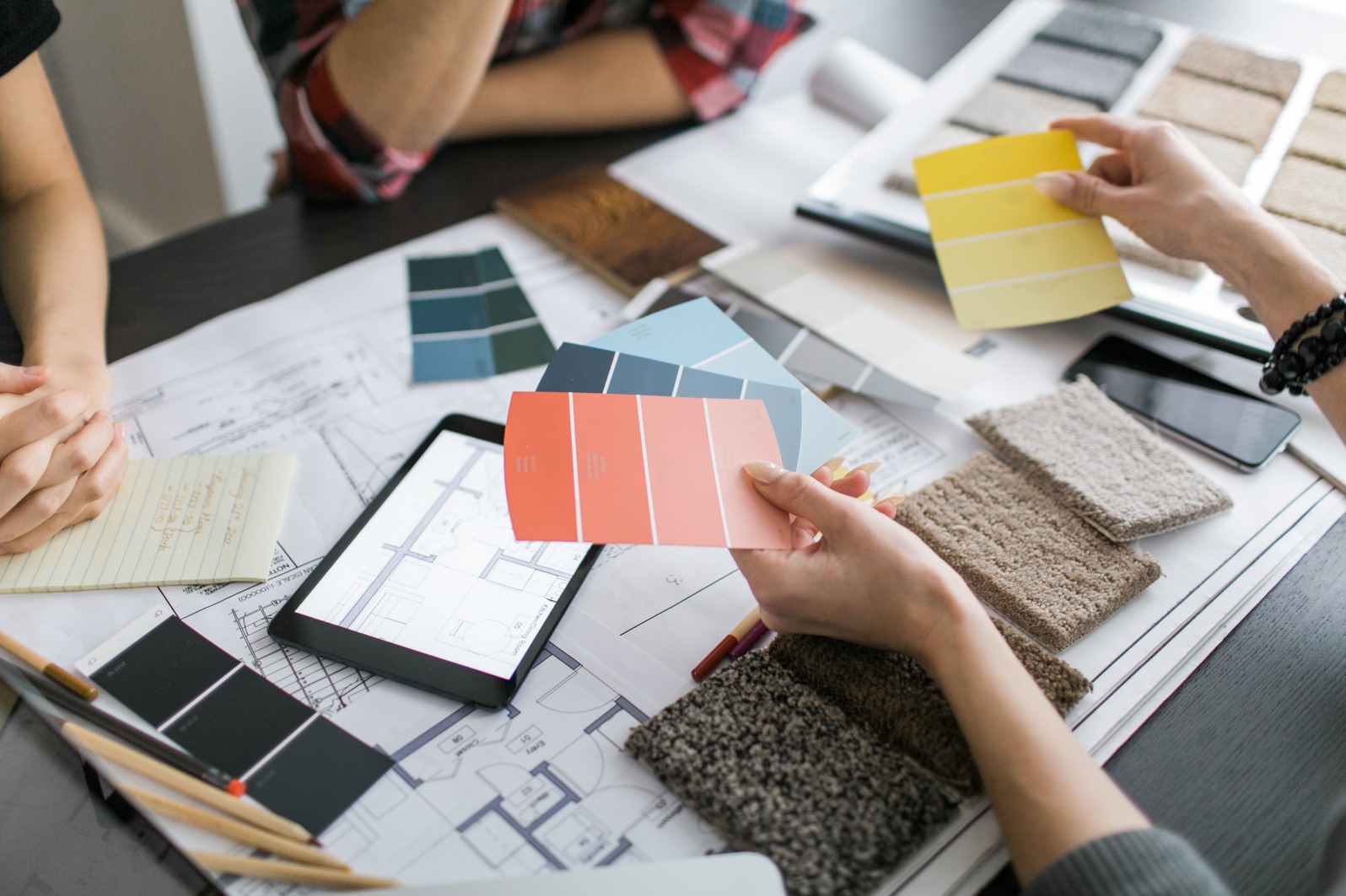 people holding color palettes and rug samples for decorating